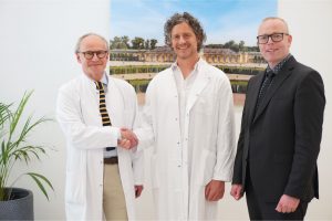 Handschlag zwischen Wilfried Sießbüttel und Dr. Kai Junghans zur Übergabe der ärztlichen Leitung der Klinik Sanssouci Potsdam, daneben Geschäftsführer Mathias Mielke.